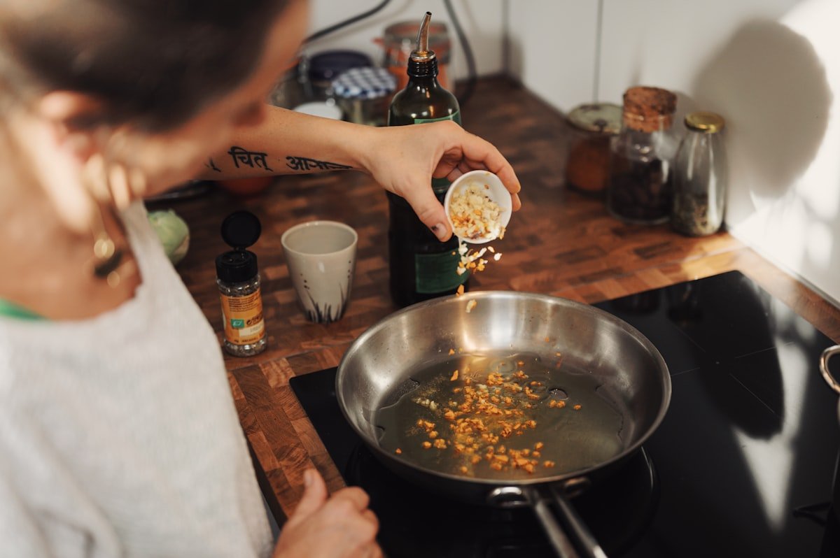 Stainless steel cooking - person sautéing vegetables in a pan on the stove